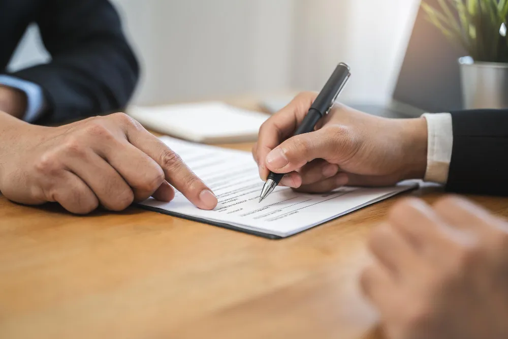 Pessoas discutindo e assinando documento sobre como anular contrato de promessa de compra e venda.