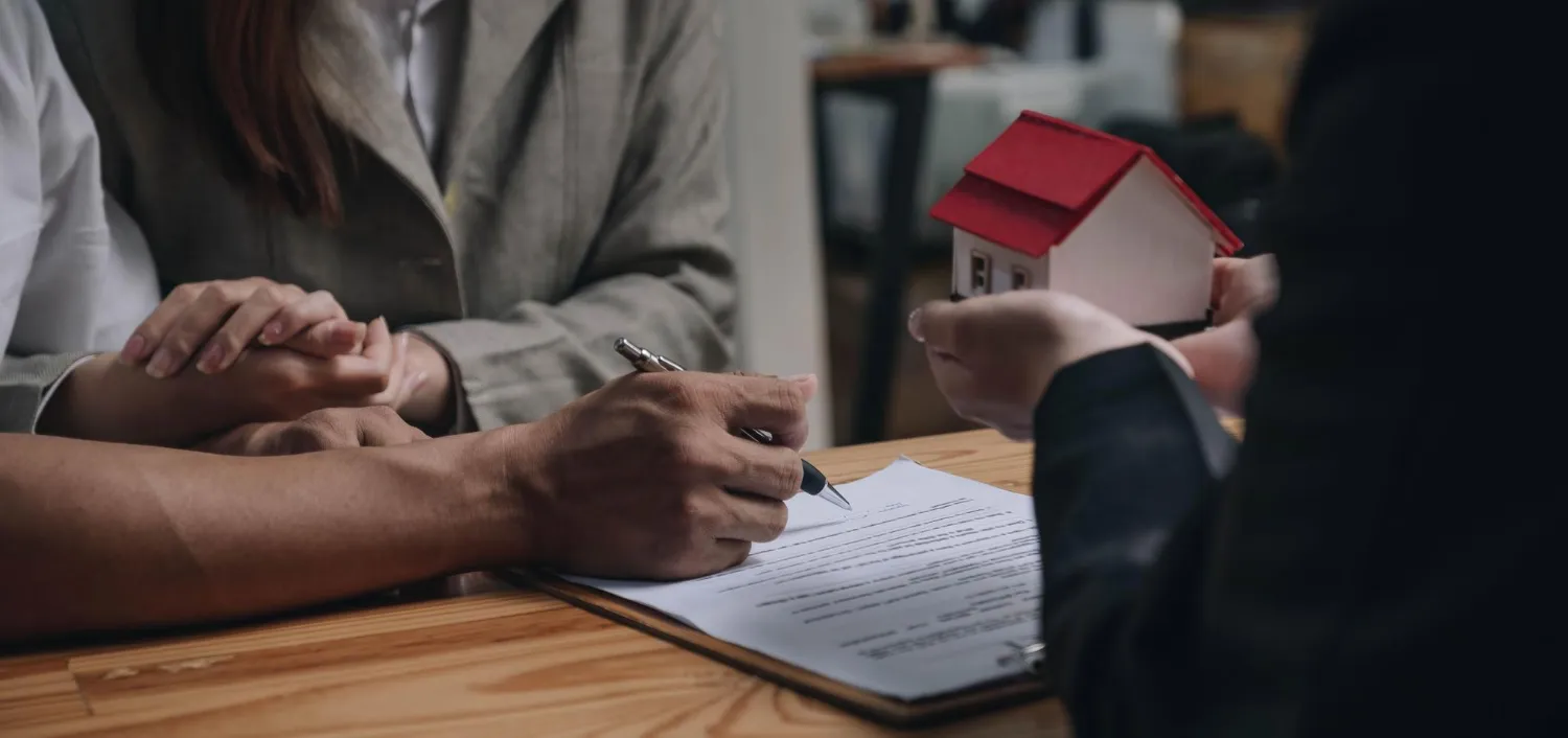 Assinatura de contrato com miniatura de casa, questionando se bens em holding familiar podem ser penhorados.